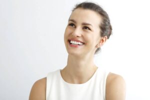 Woman with bright smile and healthy gums after successful LANAP laser gum therapy.