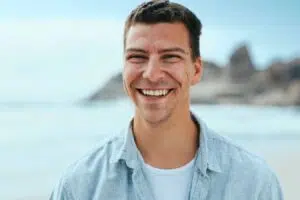 Smiling man outdoors representing confidence after LANAP treatment for gum disease and possible bone regeneration.